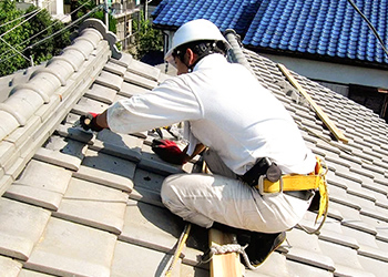 屋根で作業するスタッフ
