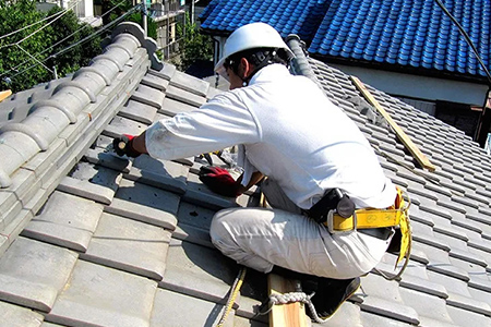 屋根で作業するスタッフ